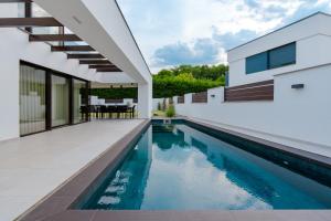 an external view of a house with a swimming pool at Villa Glam Wellness & Spa Retreat in Mogyoród