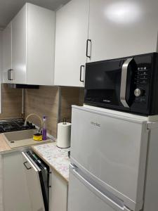 a kitchen with a microwave on top of a refrigerator at Alina Home in Mediaş +7 photos