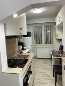 a kitchen with white cabinets and a stove top oven at Alina Home in Mediaş