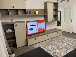 a living room with a flat screen tv on a shelf at Alina Home in Mediaş