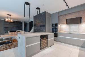 a kitchen with a island with an oven at Villa Glam Wellness & Spa Retreat in Mogyoród