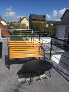 a wooden bench sitting on top of a roof at La maison spacieuse et confortable in Deauville