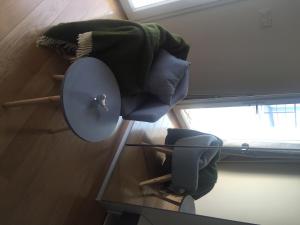 a room with a chair and a lamp on a table at La maison spacieuse et confortable in Deauville
