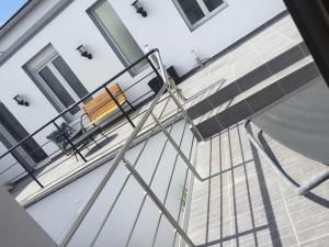 a wooden bench on a balcony of a house at La maison spacieuse et confortable in Deauville +8 photos
