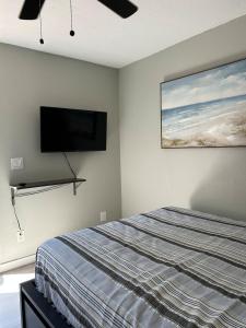 a bedroom with a bed and a flat screen tv on the wall at Studio one bed in Clermont