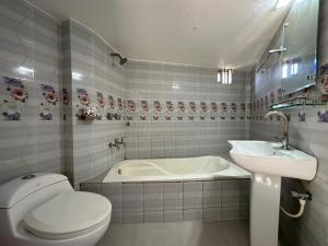 a bathroom with a toilet and a sink and a tub at Hotel Nice Look Kuakata in Kuākāta