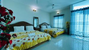 a bedroom with two beds and a christmas tree at Hotel Nice Look Kuakata in Kuākāta