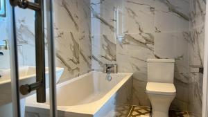 a bathroom with a tub and a toilet and a sink at Emerald Tide Hotel - Blackpool in Blackpool +19 photos