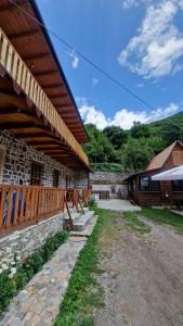 a stone building with a wooden roof and a patio at Guest House in Theth Agostini in Theth
