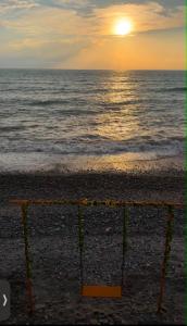 a sunset on the beach with a volleyball net at Mari House in Buknari