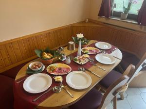 a wooden table with plates of food on it at Caldener Hof in Calden +22 photos