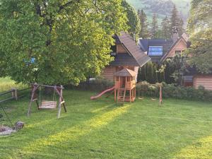 a yard with a playground and a house at Villa Szarotka in Dzianisz