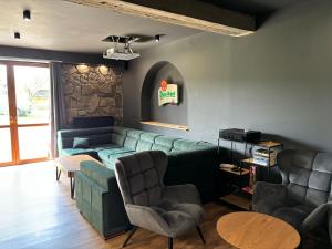 a living room with a green couch and chairs at Villa Szarotka in Dzianisz
