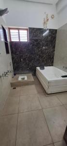 a large bathroom with a tub and a bath tub at The Green stays in Madurai