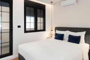 a bedroom with a white bed with blue pillows at One bedroom Belane Rezident in Tivat