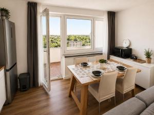 a living room with a dining room table with chairs and a window at Apartment Hannover - Langenhagen center in Hannover
