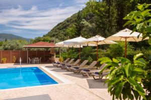 a swimming pool with lounge chairs and umbrellas next to at Villa Ligero in Palaiokatoúna