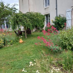 a garden with flowers in front of a house at chambre d'hôte les avettes in Réméréville
