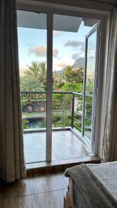 a bedroom with a large glass door to a balcony at Le Morne Kite Villas in La Gaulette
