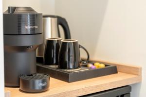 a coffee maker on a wooden shelf next to a coffee pot at Naiades Guest House in Sálakos