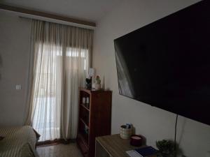 a living room with a large flat screen tv on the wall at Ground floor Apt with a garden view in Limassol