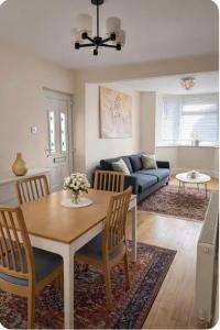 a living room with a table and chairs and a couch at London Heathrow Accommodation in Hillingdon