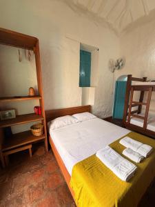 a bedroom with a bed with towels on it at Habitación Laurel Y Tomillo Independiente in Barichara