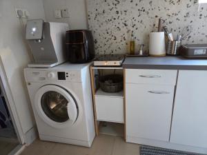 a kitchen with a washing machine and a counter at Ground floor Apt with a garden view in Limassol