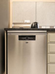 a stainless steel dishwasher in a kitchen with a counter at Oceanfront Escape Beach House in Strand