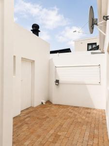 a room with a white wall and a garage at Oceanfront Escape Beach House in Strand