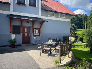 a patio with a table and chairs in front of a house at Penzion U Zemánků in Jablonec nad Jizerou