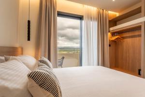 a bedroom with a bed and a large window at Naiades Guest House in Sálakos