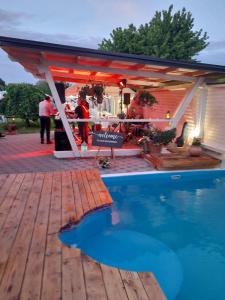 a pavilion with a swimming pool next to a house at Lucija in Tenja