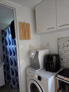 a kitchen with a washing machine and a microwave at Ground floor Apt with a garden view in Limassol +4 photos