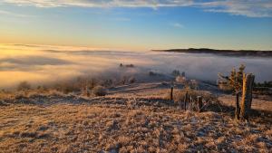 a view of a foggy field with a fence on a hill at Apartmánový dom Budiná in Budiná