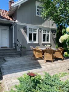 a wooden deck with a table and chairs in front of a house at Mølleråsen Apartment in Sandefjord