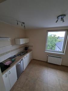 a kitchen with white cabinets and a window at Dom na Kościelnej in Ślesin +10 photos