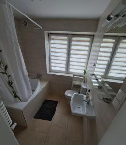 a bathroom with a sink and a tub and a toilet at Dom na Kościelnej in Ślesin