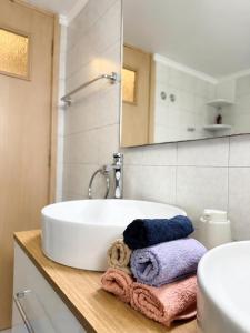 a bathroom with a sink and a tub with towels at Blossom Apartment Kos in Ampavris +47 photos