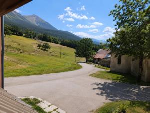 a view of a driveway with mountains in the background at Six Duplex à la montagne POMPIERY in Seyne