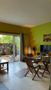 a living room with a table and chairs and a patio at Le Morne Kite Villas in La Gaulette