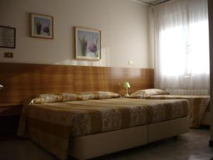 1 dormitorio con 2 camas y ventana en Hotel Sport, en Portogruaro