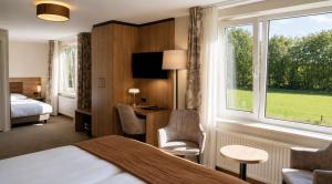 a hotel room with a bed and a large window at Hotel de Landmarke Ootmarsum in Groot-Agelo