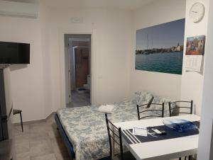 a room with a table and a bed and a television at Villa Maldera-case vacanza-loft- loft queen specchio in Trani