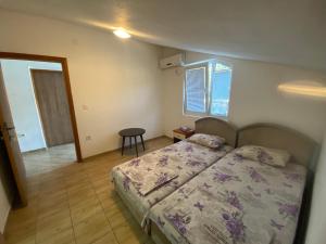 a bedroom with a bed and a table and a window at Mia in Glavatske Kućice +7 photos