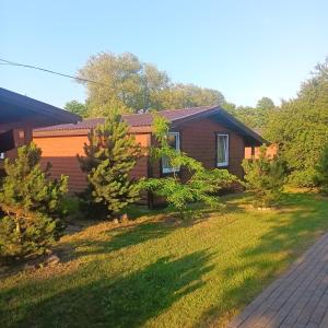 a house with trees in front of a yard at Liepsna Šventoji in Šventoji