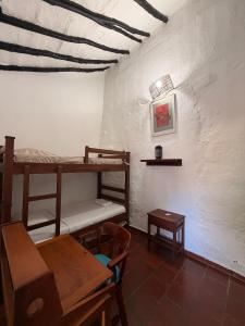 a room with two bunk beds and a table at Casa Garaje in Barichara