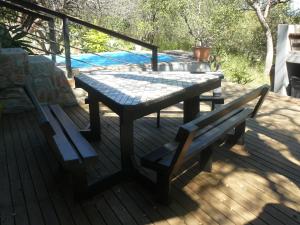 a picnic table and a bench on a deck at Tjhora Sunset Cottage in Cambridge