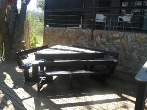 a wooden bench sitting on top of a deck at Tjhora Sunset Cottage in Cambridge