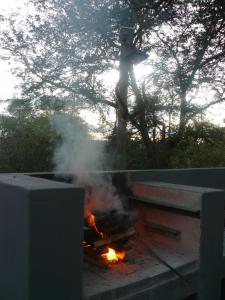a man standing on top of a fire at Tjhora Sunset Cottage in Cambridge